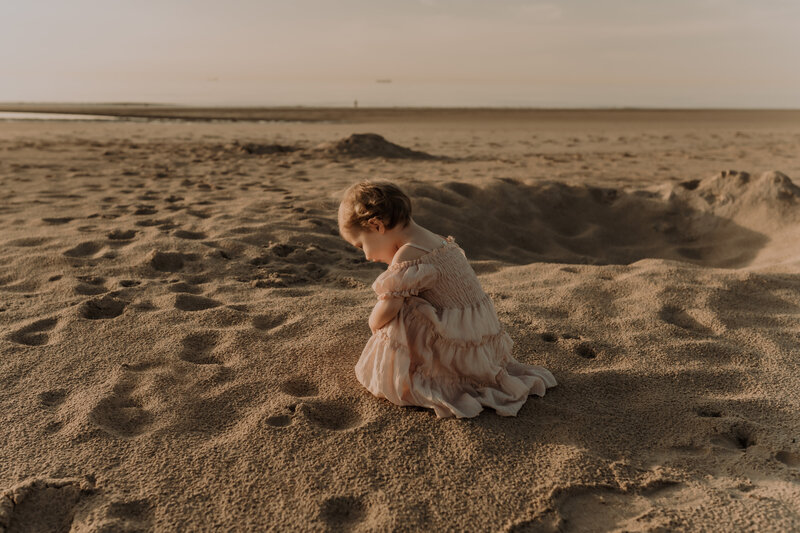 Meisje speelt op het strand tijdens gezinsshoot in Knokke.
