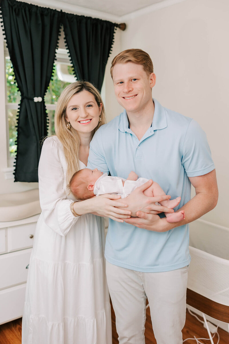 Mom holding new baby boy during their augusta family photographer session