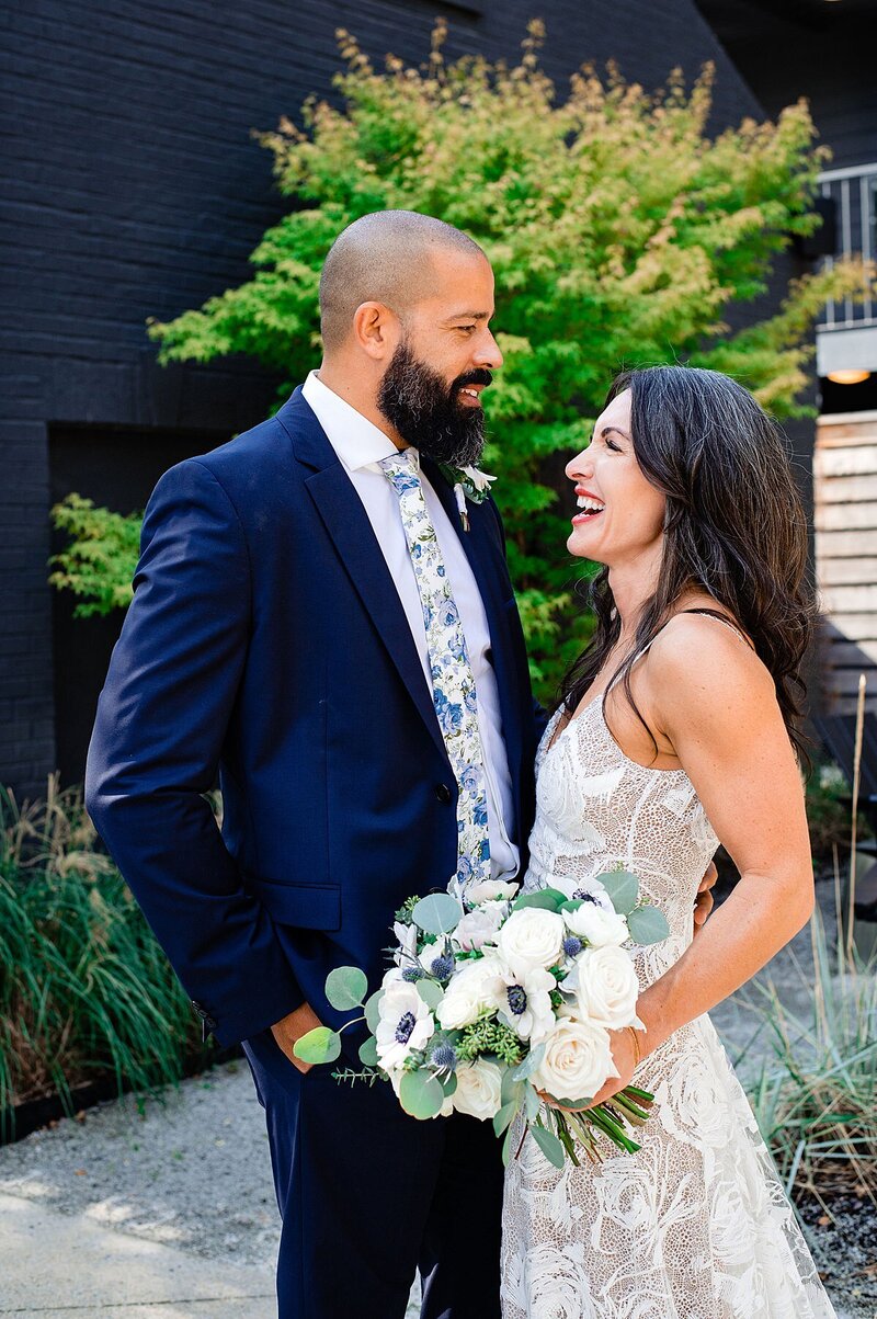 Newly married couple laughing moments after eloping outside a Nashville BODE hotel