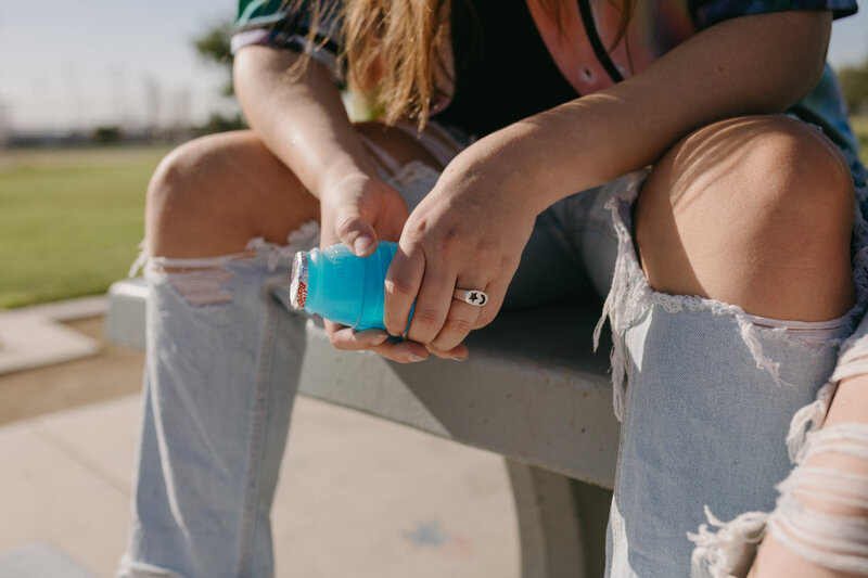 Girl holding a blue juice.