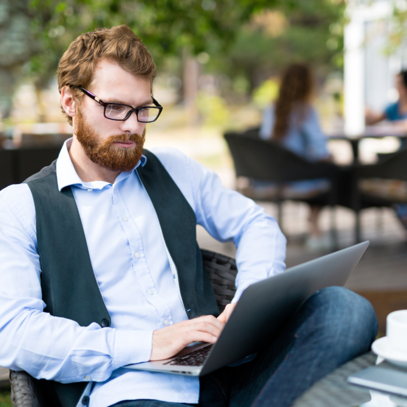 Man with red hair and beard sitting and typing on laptop
