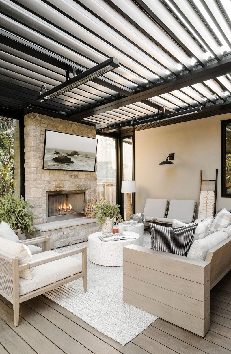 An outdoor living space with a suncoast enclosure and outdoor furniture with stone fireplace. 