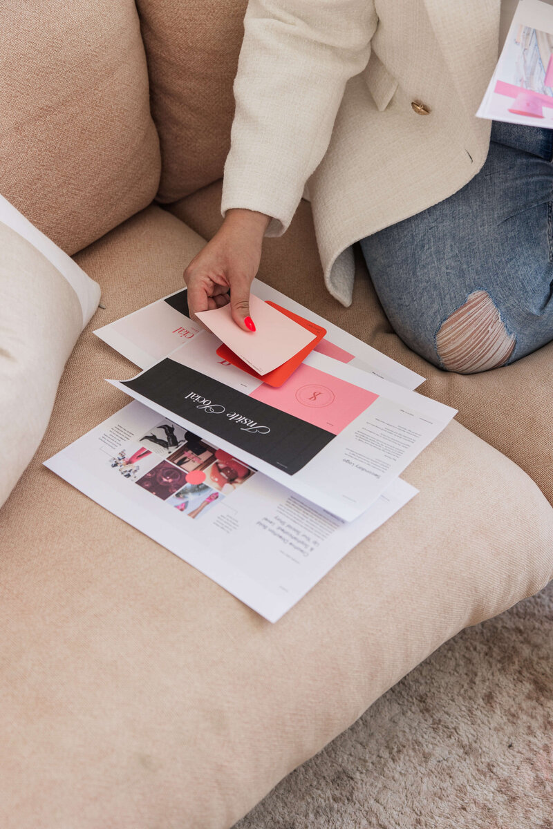 Leith sitting on a lounge, reviewing a brand presentation with colour swatches