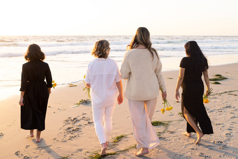 Women walking toward the Pacific Ocean at sunset
