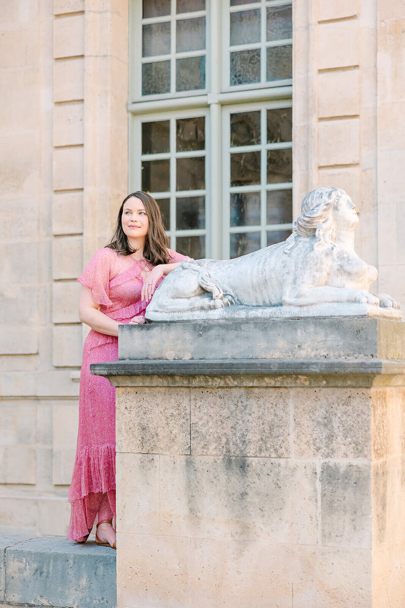 Solo woman in a pink maxi dress during a Paris photoshoot on Île Saint-Louis in the city center.