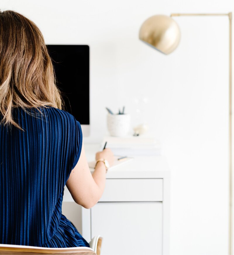 woman at desk, writing notes