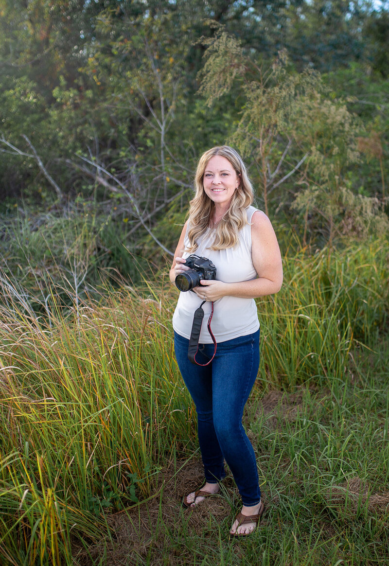 Golden hour portrait holding camera and smiling 