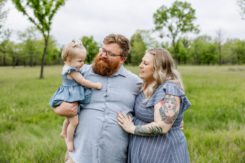 Parents with daughter standing in a field in Bonne Terre Missouri.