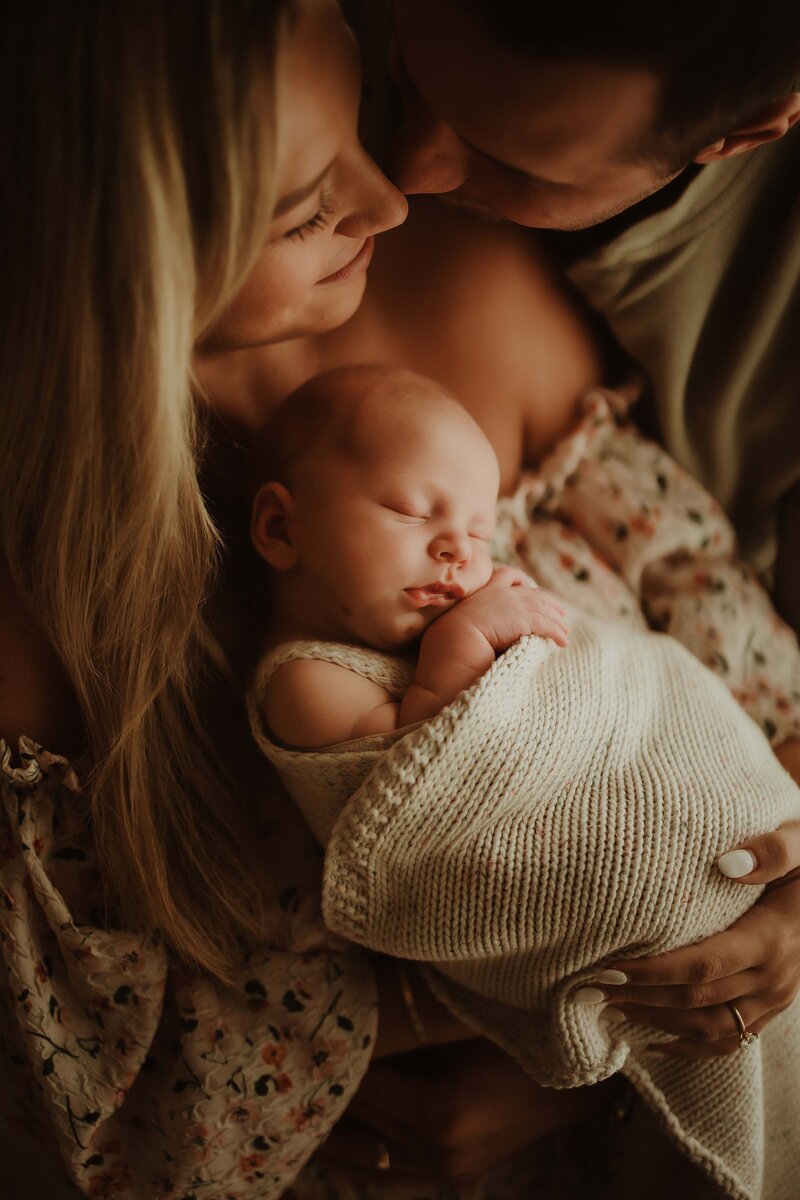 Close-up of mother kissing baby’s forehead, photographed by Sydney newborn photographer Sophie Lea.