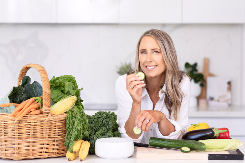Nutritionist at kitchen counter with a basket of fresh produce