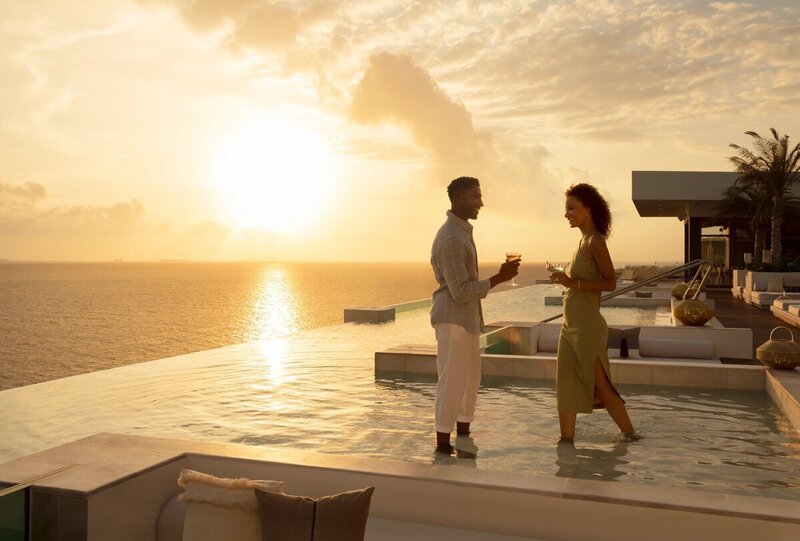 man proposing to girl in pool to show concierge travel for honeymoons GG Mack