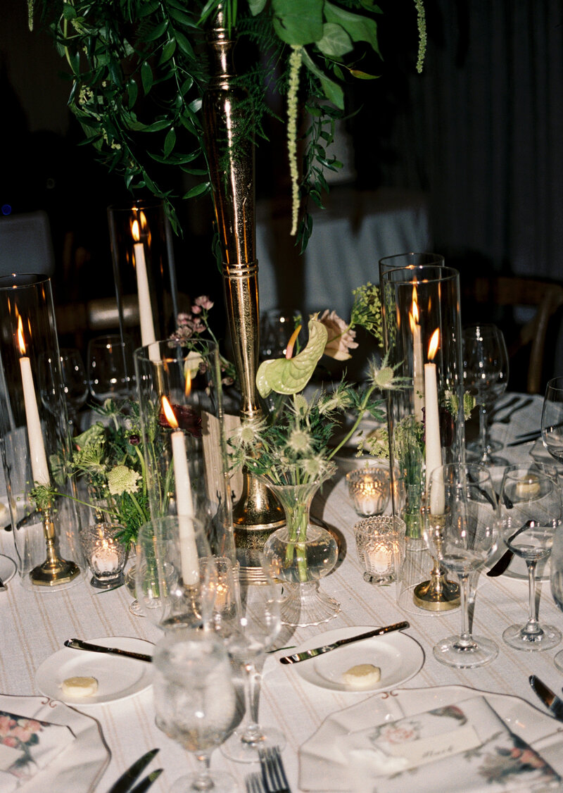 a wedding tablescape on film with greenery and candles