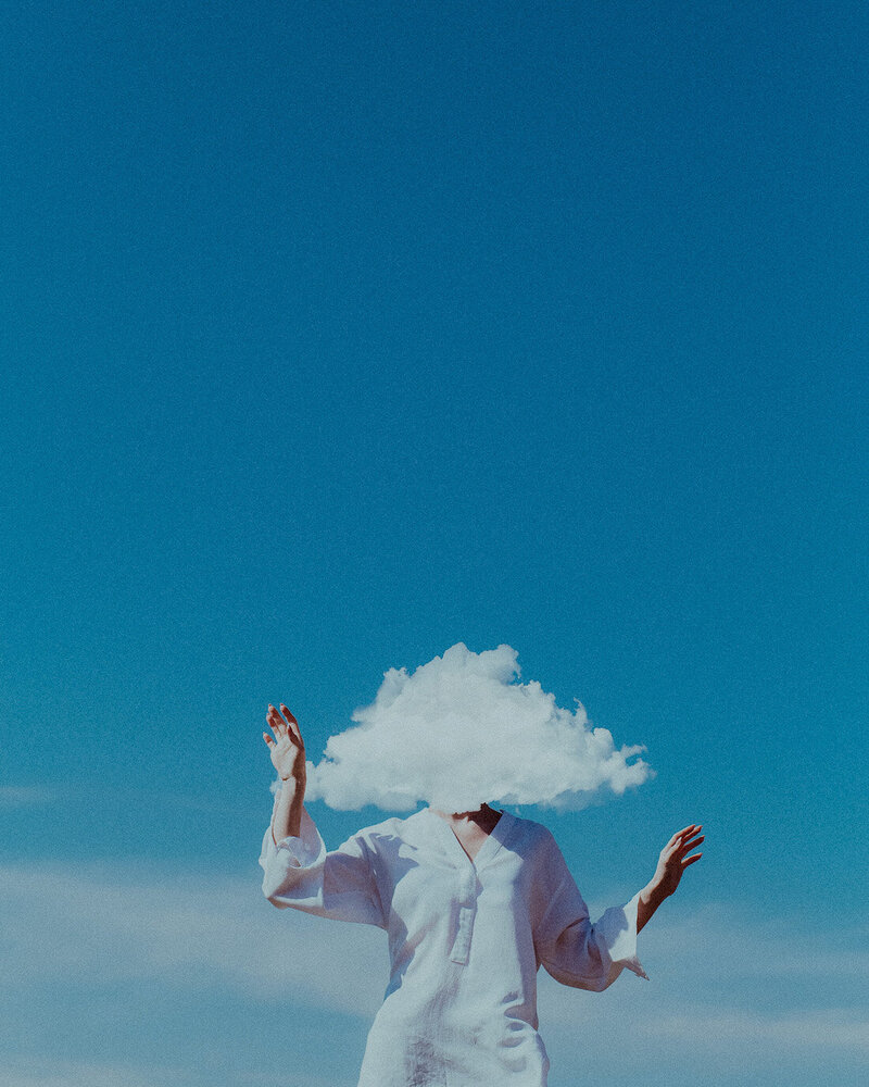 a woman in white with a cloud head and sky blue background