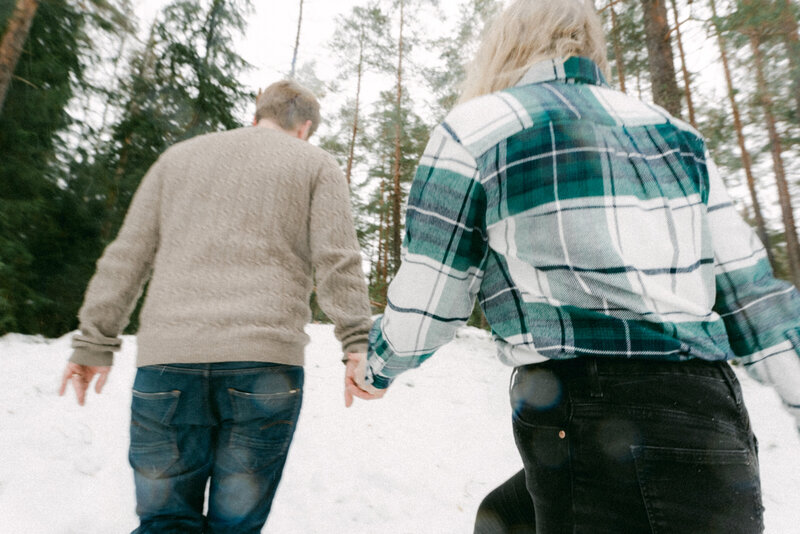 Kihlapari metsässä talvisessa kihlakuvauksessa valokuvaaja Hannika Gabrielssonin ottamassa valokuvassa