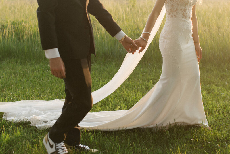 bride and groom holding hands on grass