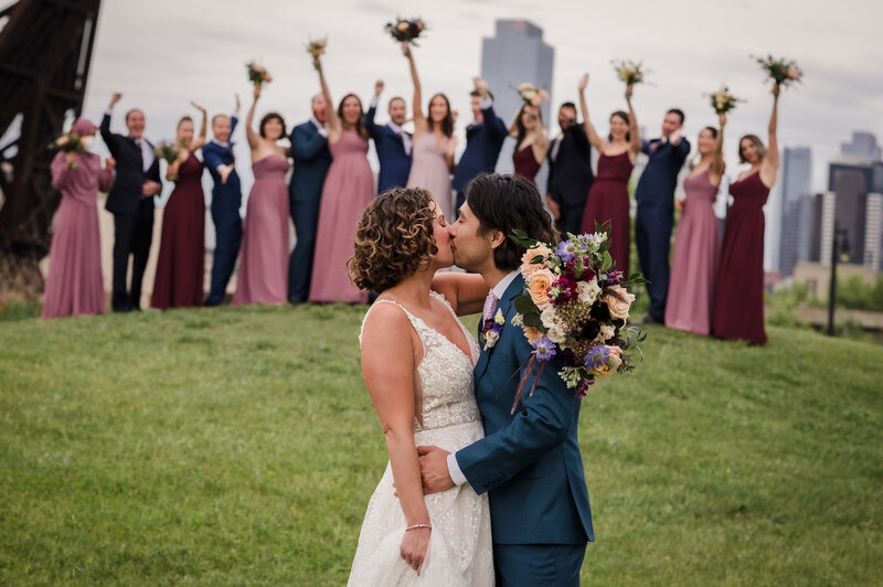 Wedding party cheer on bride and groom from behind