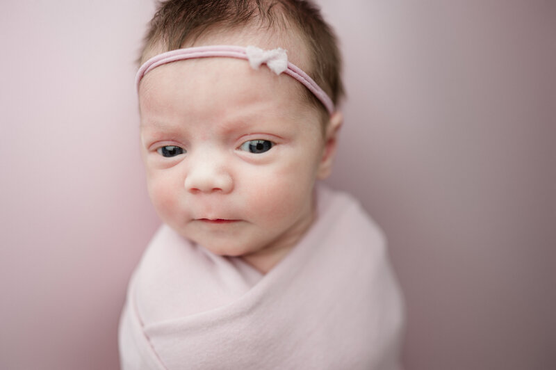 Newborn wrapped in a soft pink blanket