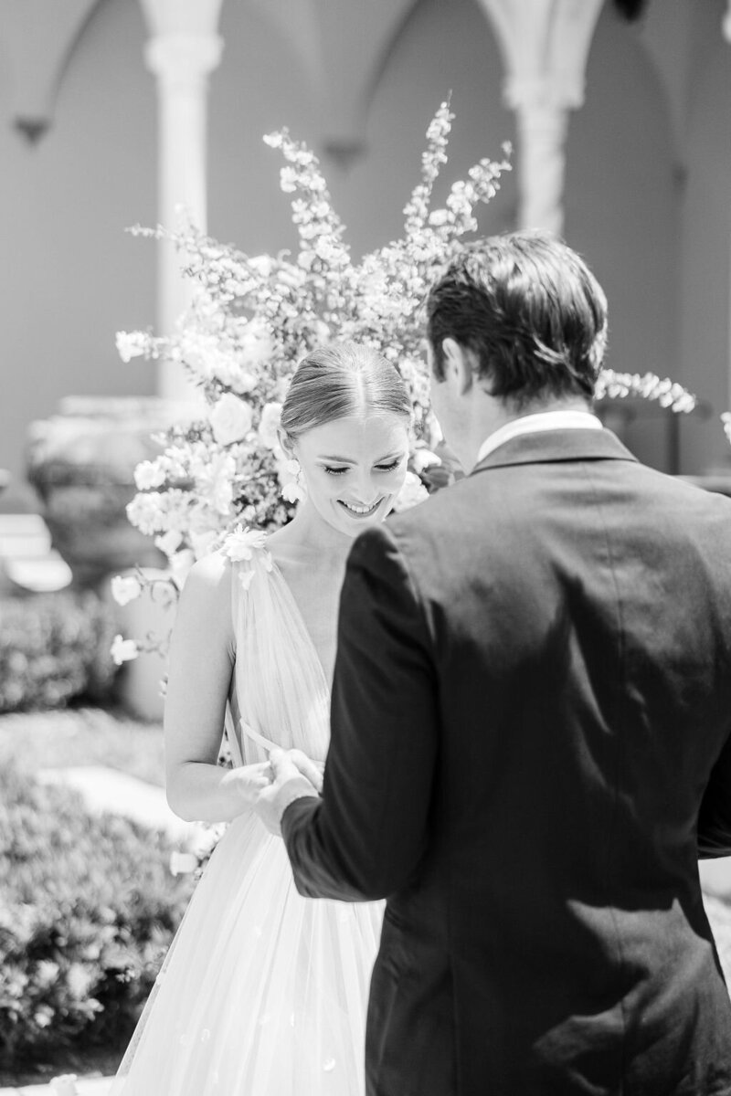 A radiant bride smiles as she exchanges vows with her groom during an intimate wedding ceremony at The Ringling Museum in Sarasota, Florida. Captured by Amia Marcell Destination Wedding Photographer.