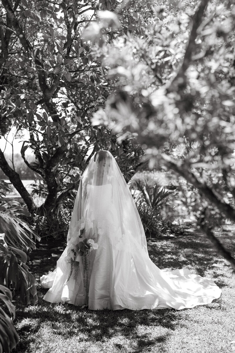 Maid of honor applies bride's makeup, captured by Oahu wedding photographer.