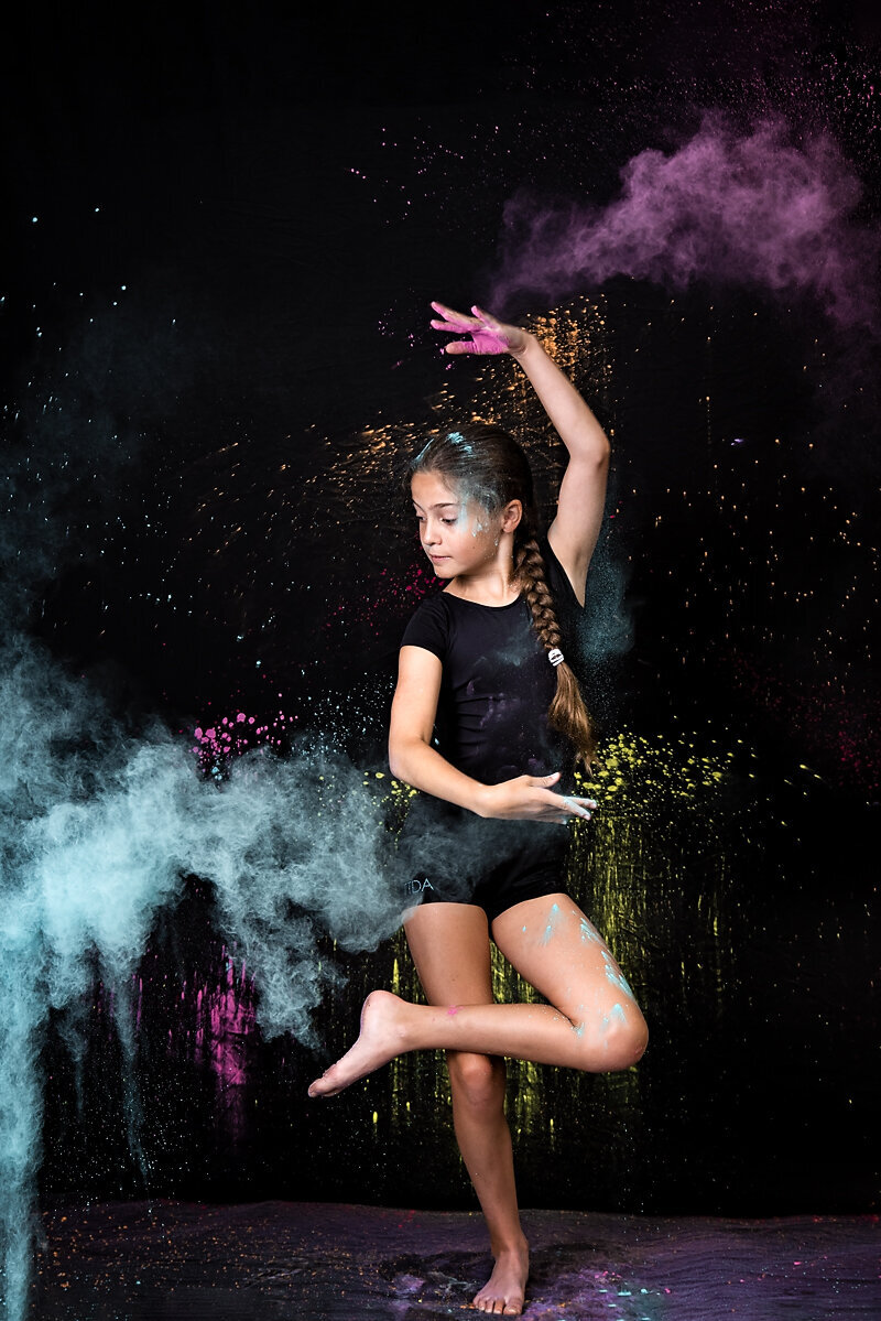 Dancer in black tossing colored chalk powder in Jefferson NJ
