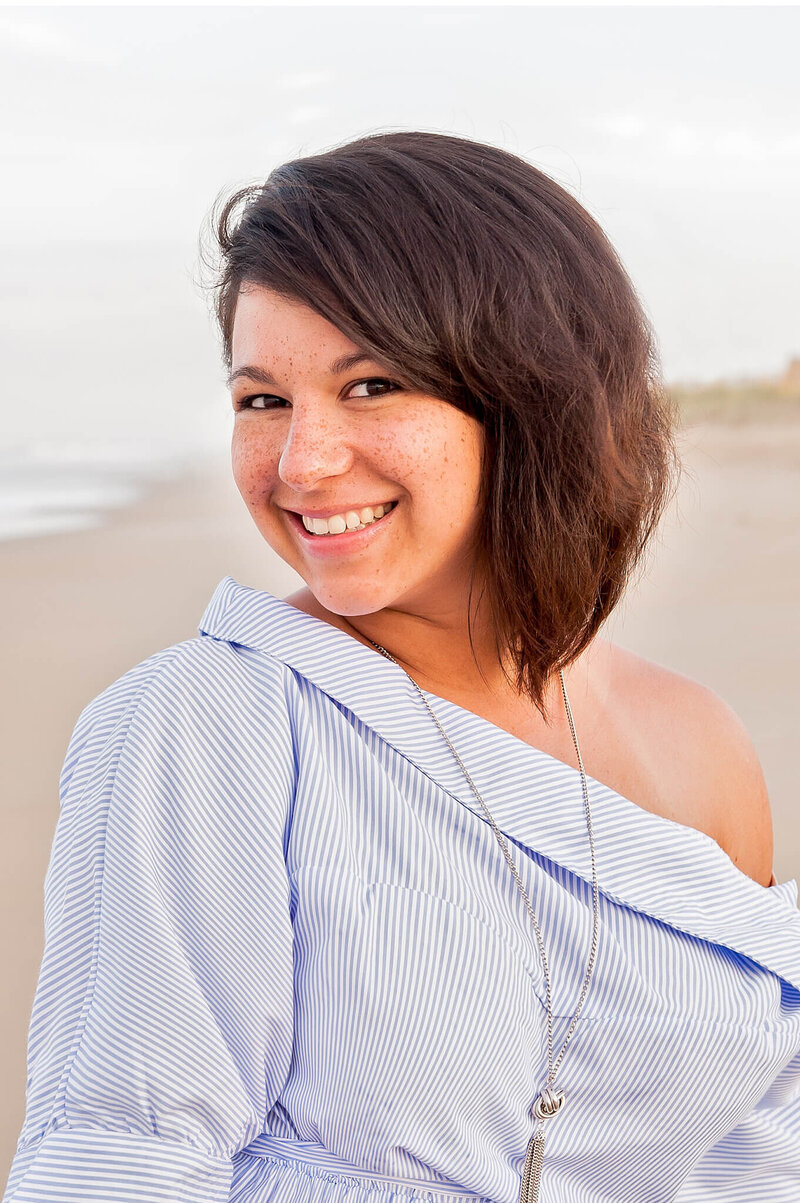 woman at beach in a blue striped shirt