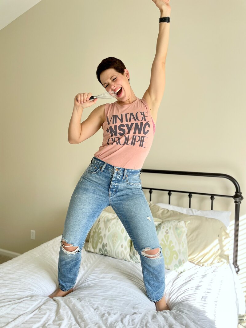 Megan Ludwick content manager dancing and singing on bed