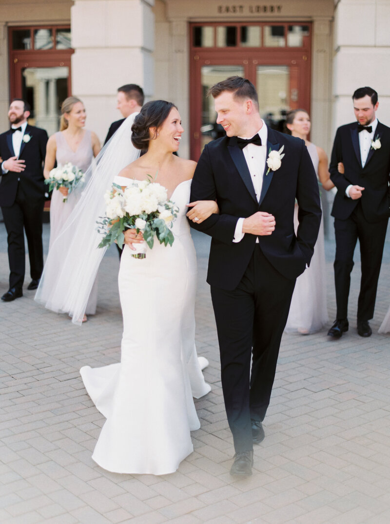 Bride and groom happily walking out of wedding venue photographed by Chicago editorial wedding photographer Arielle Peters
