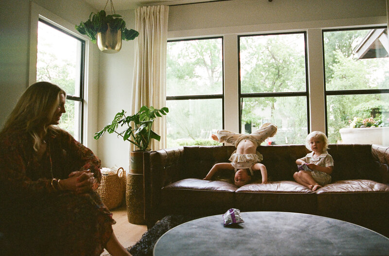 Mother and father sitting on bed with toddler and baby for sweet at home family session in Austin by Amber Vickery Photography