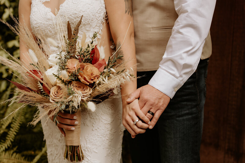 A couple holding hands showing their wedding rings