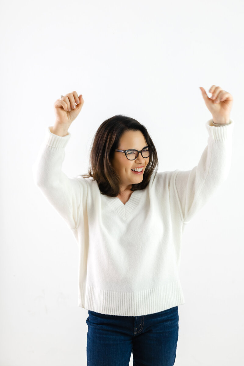 Woman celebrating with raised arms symbolizing freedom and confidence from stress mastery