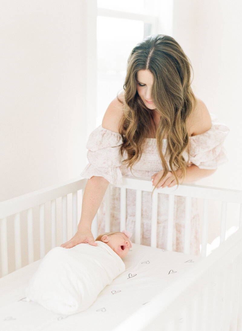 Mom cradles new daughter in Raleigh newborn session. Photographed by Raleigh newborn photographer A.J. Dunlap Photography.
