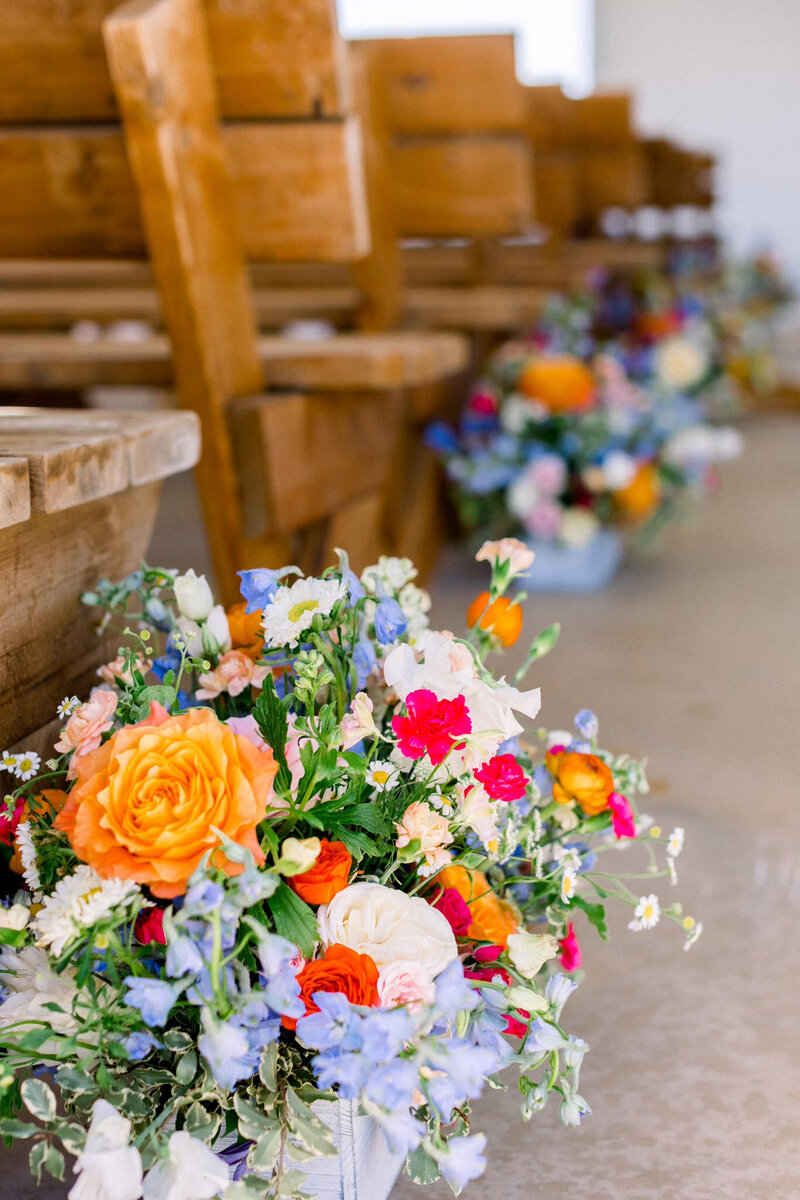 ceremony aisle decorated with bright flowers along each side