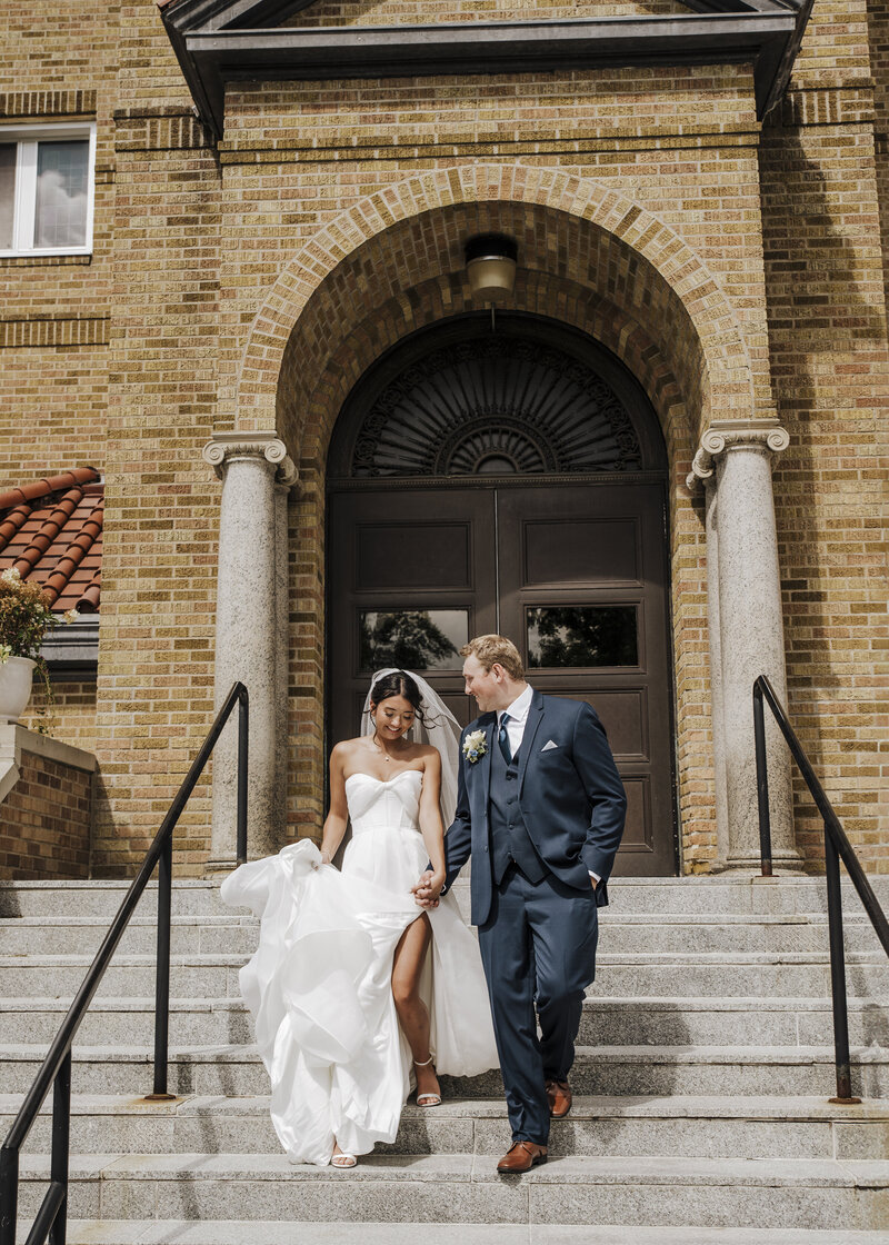 bride and groom kissing with brides veil flowing in the wind