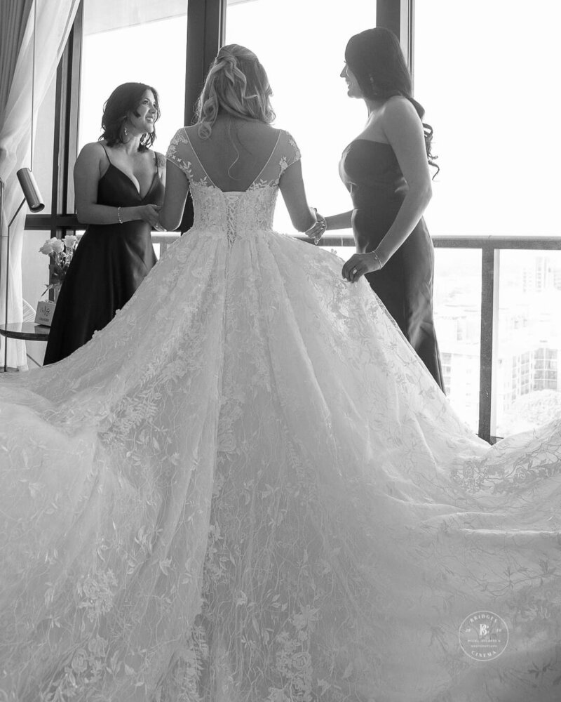 Bride being helped into her dress, captured beautifully in West Palm Beach.