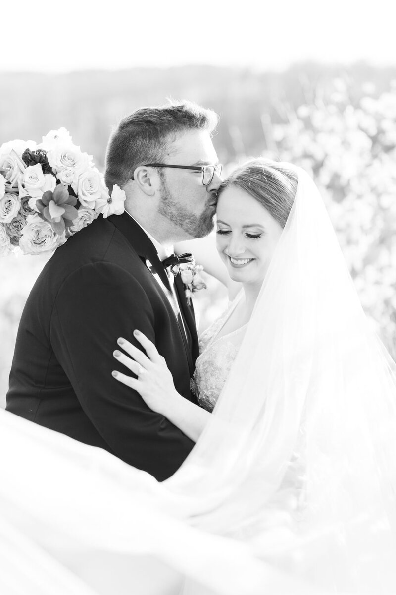 Groom kissing brides forehead