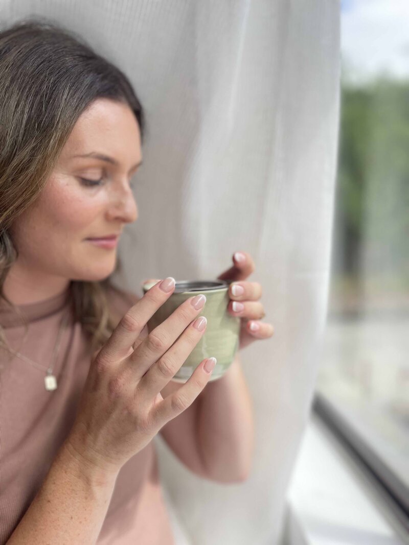 Hayley Founder of Harmony Blends, Holding a fresh brewed tea