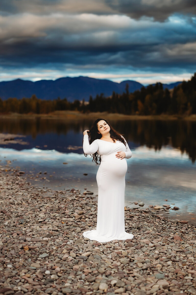 whitefish maternity photographer woman posing by flathead river