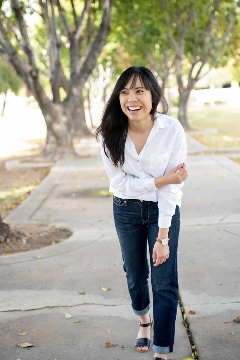 Laci smiling in a white blouse and jeans in Chandler Park