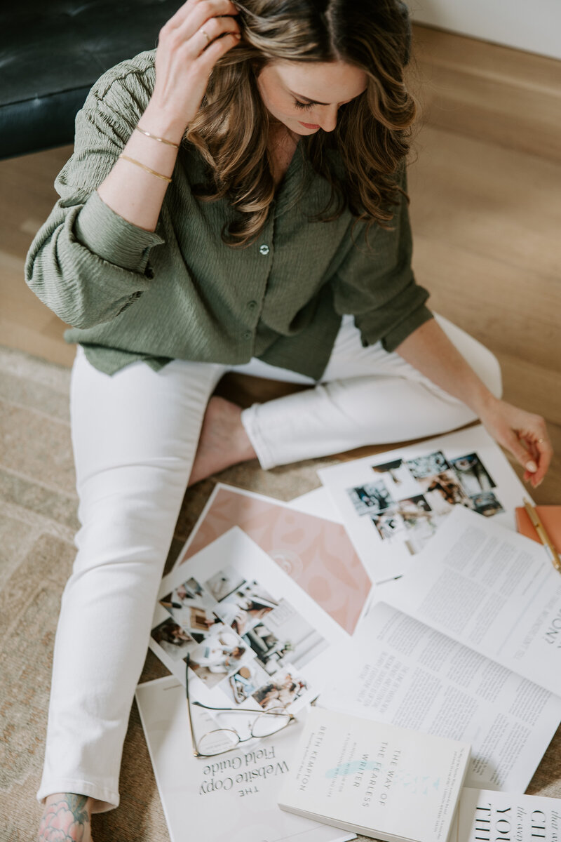 A website copywriter sitting on the floor with a magazine