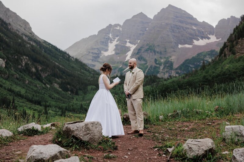 bride and groom say wedding vows during colorado elopement at maroon bells - free colorado elopement planning guide