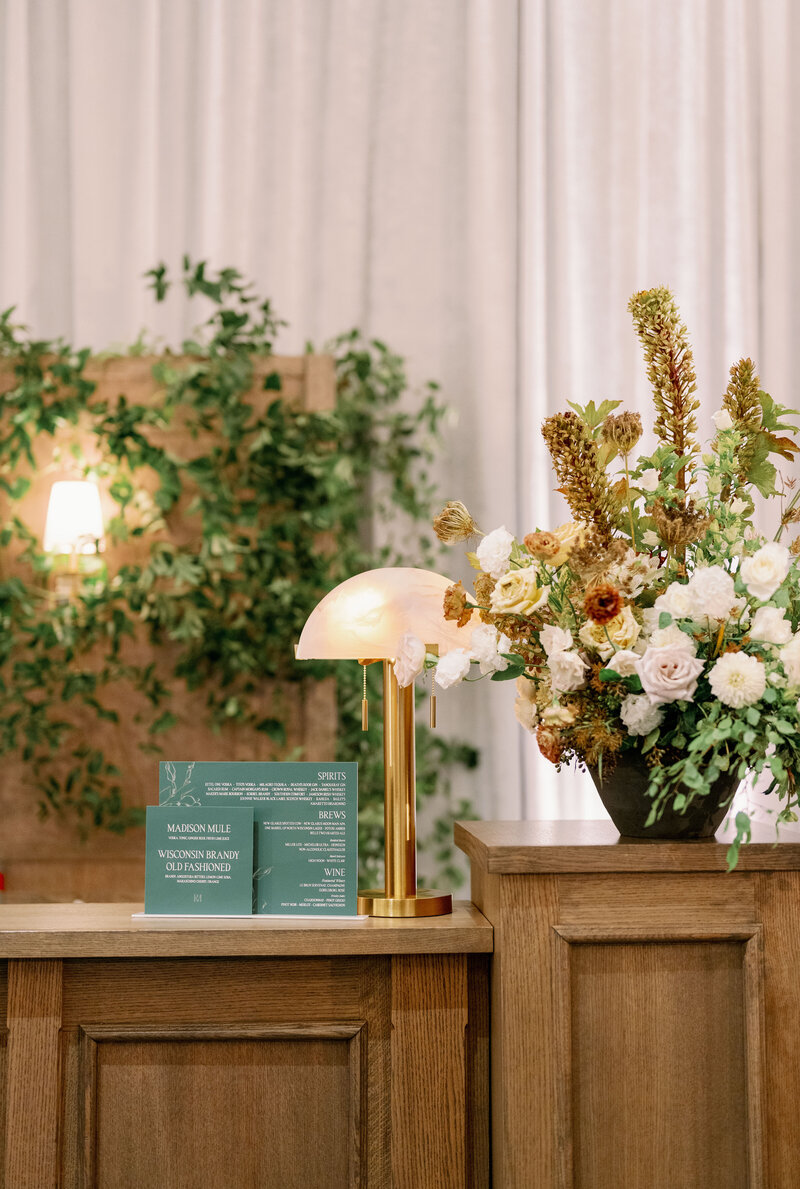 a custom wedding stationery design featuring a wedding dinner menu with a custom name tag and a flower on it on top of a white plate from alyssa amez design