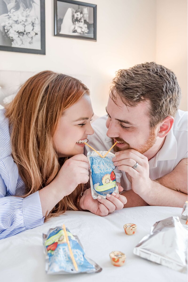 Fun and joyful moment captured: Elyse Stokes and husband sharing a Capri Sun, expressing happiness and laughter