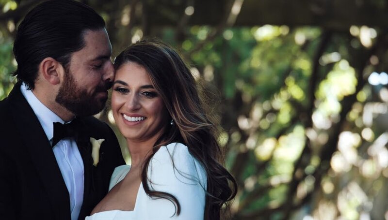 A person standing close to their partner with their nose on their forehead 
