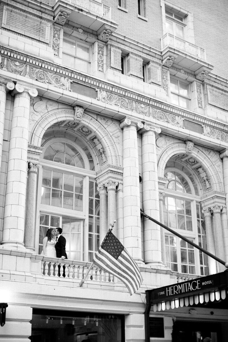 Bride and groom kiss on balcony of the Hermitage Hotel in Nashville Tennessee