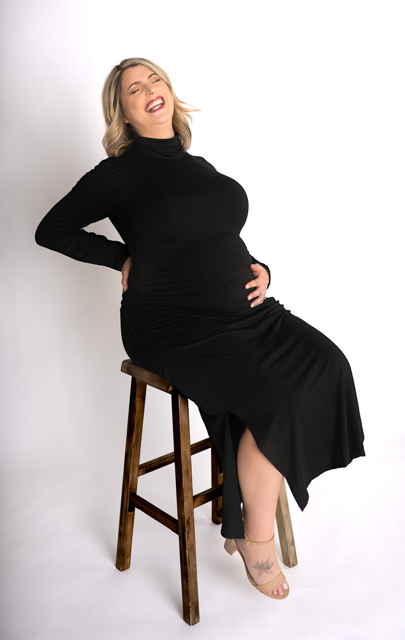 mom in purple dress holding baby bump