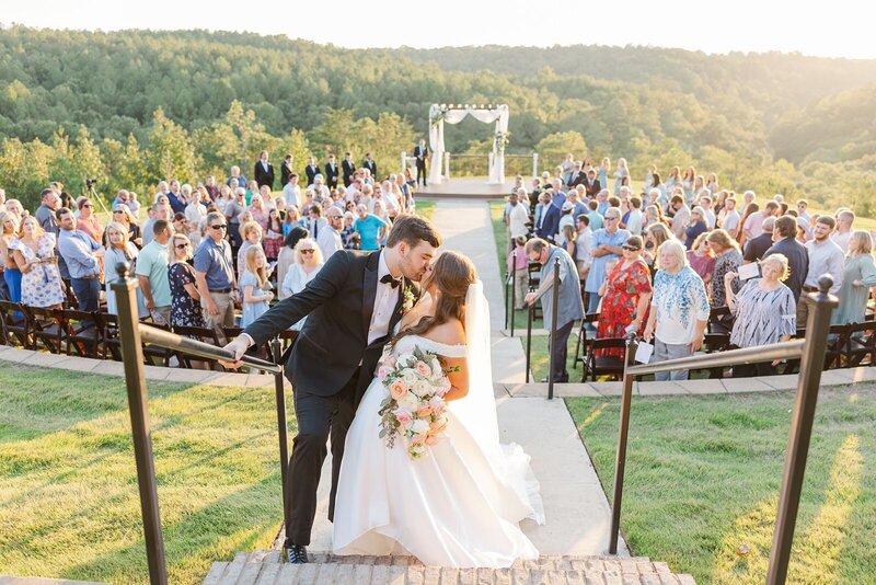 Bride and groom kiss after walking back down the aisle after taking wedding vows