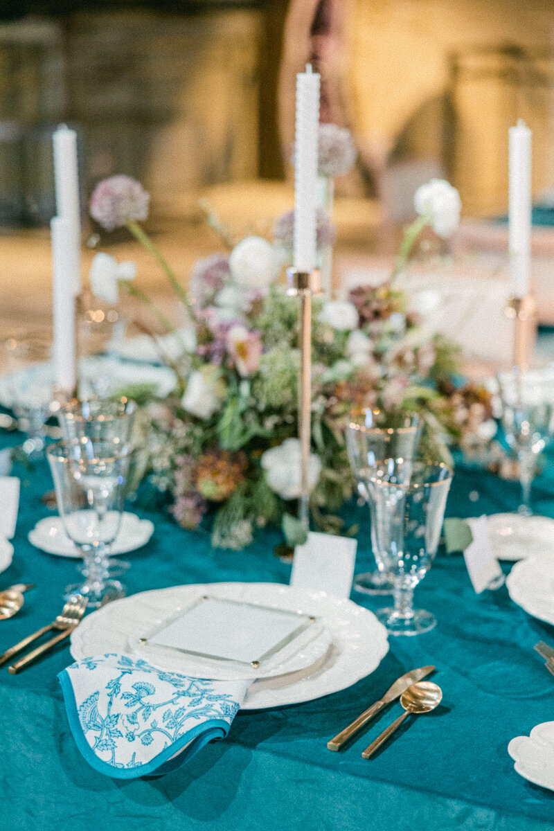 A beautifully styled wedding reception at Savannah Westin Hotel, featuring elegant blue linens, floral centerpieces, and gold-accented tableware. Designed by Allison Design for a luxury celebration.