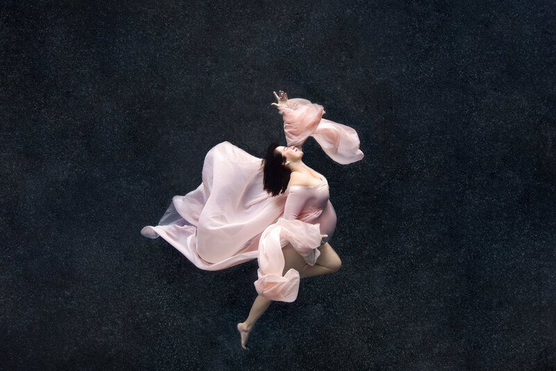 st-louis-underwater-photographer-pregnant-mom-in-pink-bodysuit-with-train-and-long-sleeves-floaing-underwater