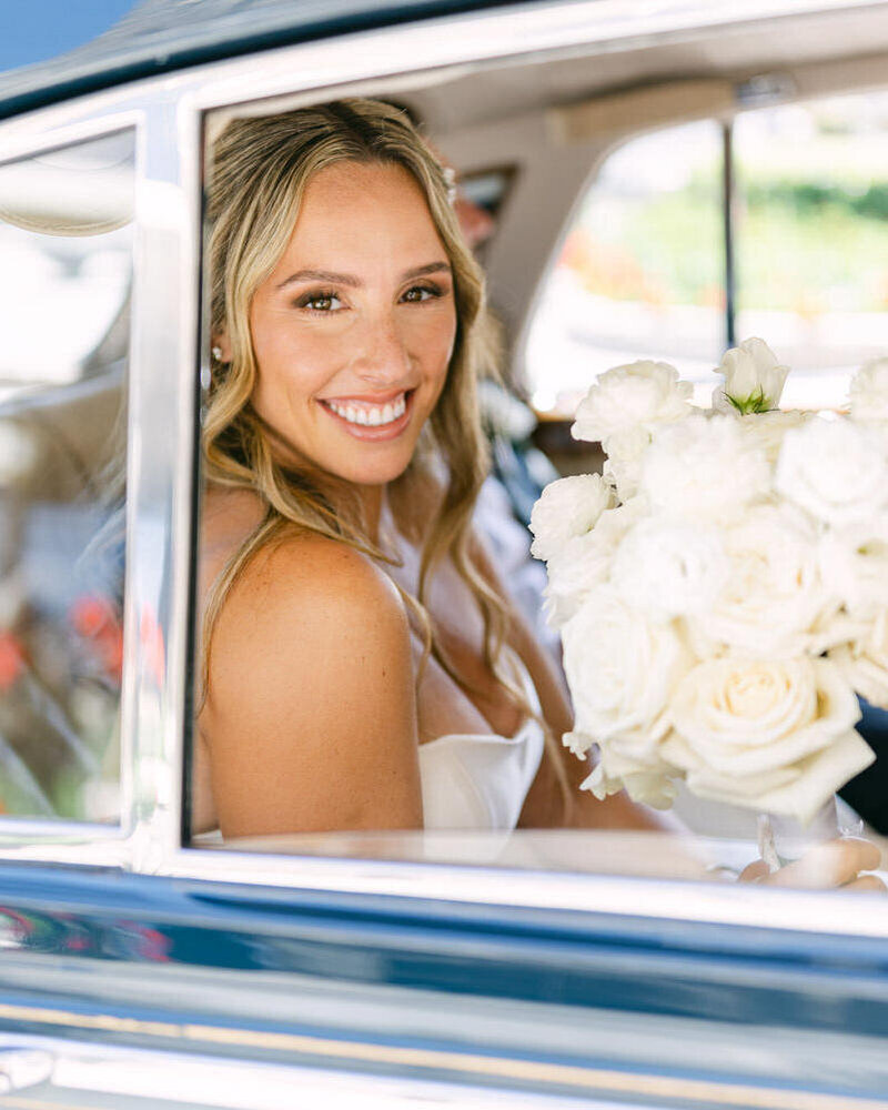 This beautiful photograph captures the bride seated in a luxury Rolls Royce on her way to the wedding ceremony at SAIT Historic Campus in Calgary, adding elegance and sophistication to her special day.