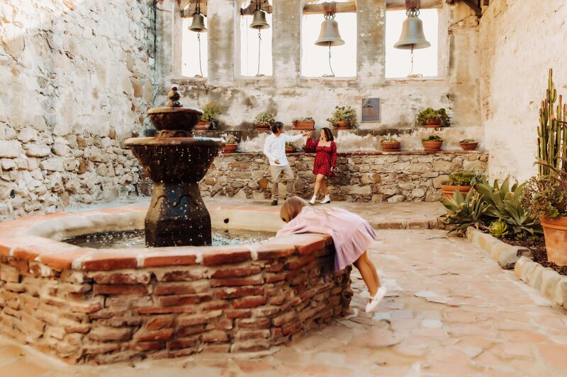 Little girl playing in the fountain at San Juan Capistrano
